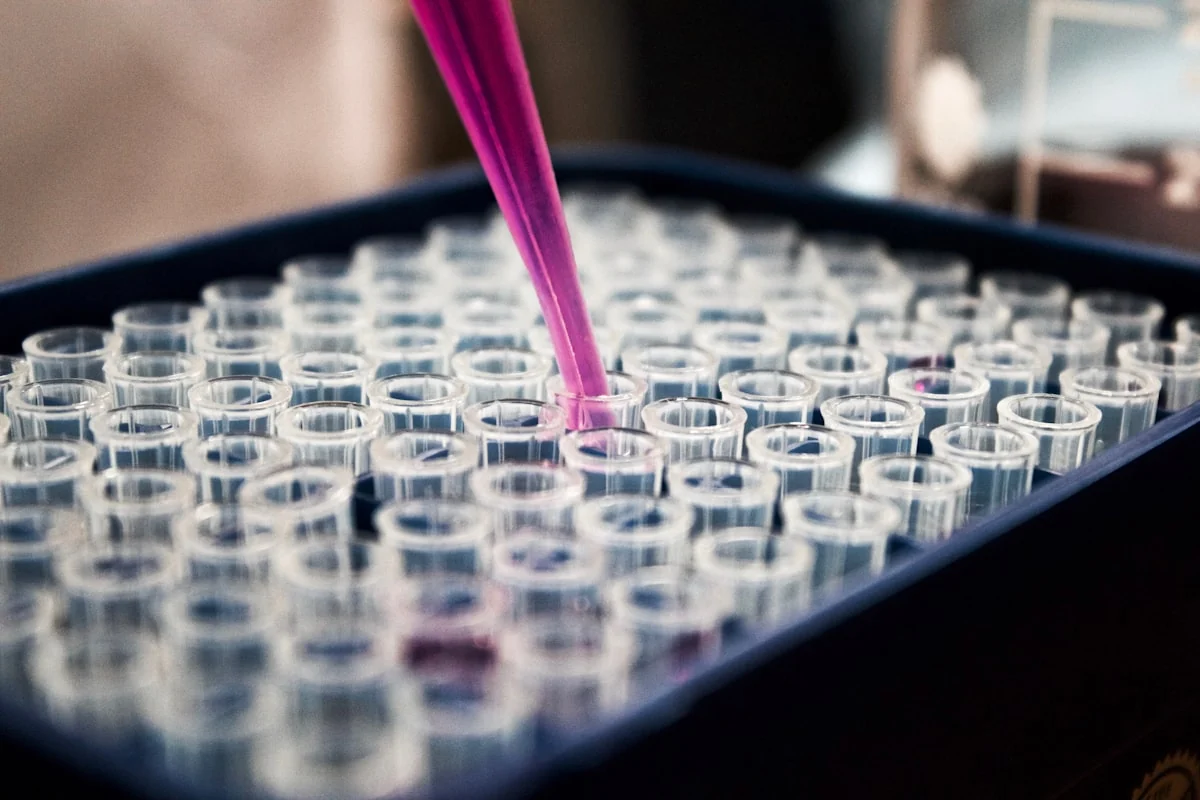 Laboratory pipette dispensing sample into a rack of test tubes during an analysis